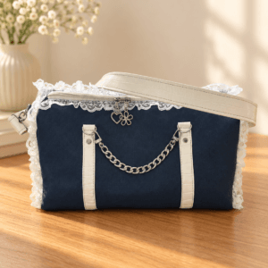 Navy handbag with white lace trim, white vertical accents, a silver-tone chain handle and a white shoulder strap.