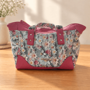 Front of a pastel daisy handbag with deep pink trim, matching floral handles and a metal Stacy’s bags tag.