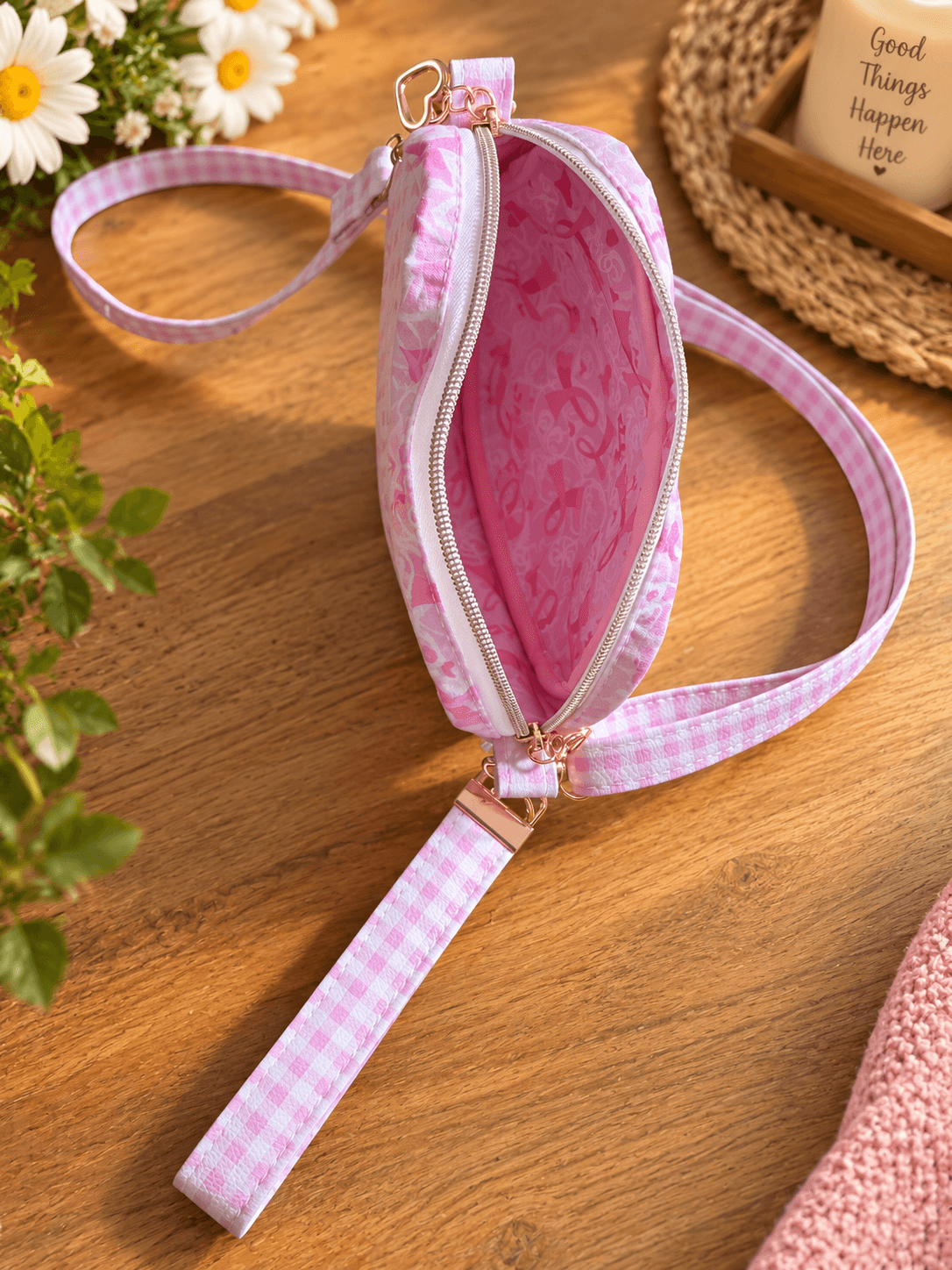 Open pink gingham heart bag showing pink patterned lining, a white zipper, matching shoulder strap and wrist strap.