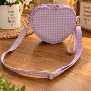 Pink and white gingham heart bag with a heart-shaped zipper pull, adjustable matching shoulder strap and wrist strap.
