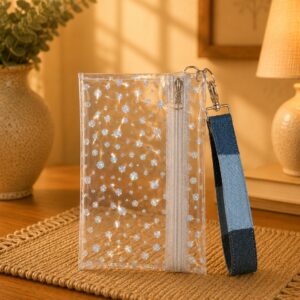 Clear Holographic Dot Wristlet with white zipper and blue patchwork wrist strap.