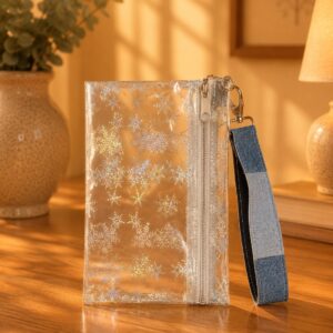 Clear Holographic Snowflake Wristlet with white zipper and blue patchwork wrist strap.