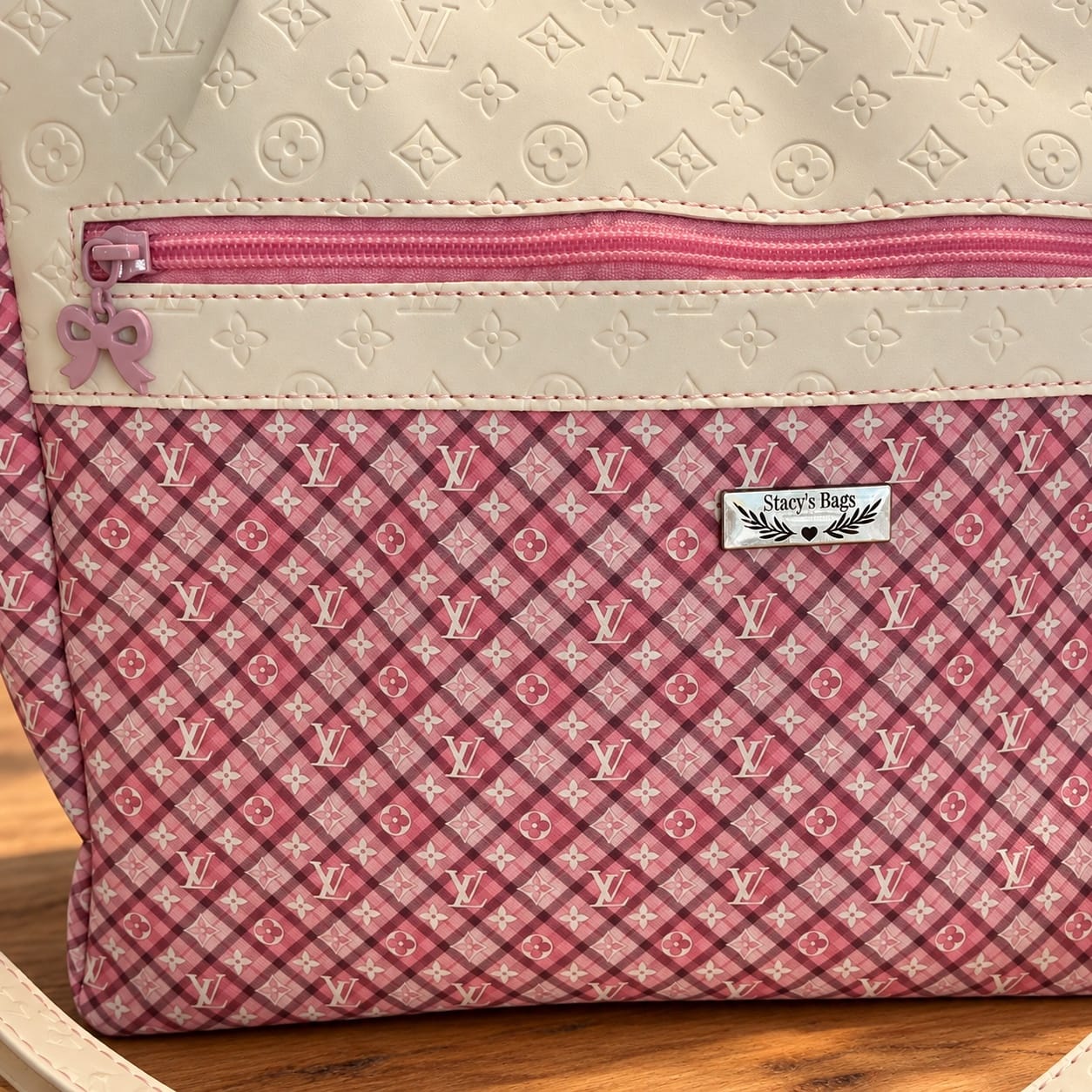 Close-up of the front pink zipper pocket and Stacy’s Bags label on the pink plaid handbag.